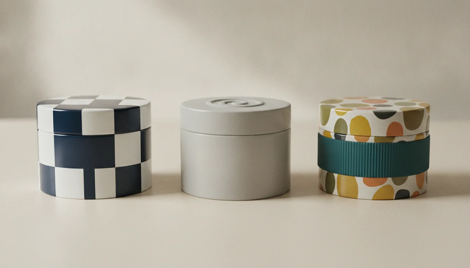 Three tins side by side showing high-contrast labels, a raised symbol, and a textured grip band